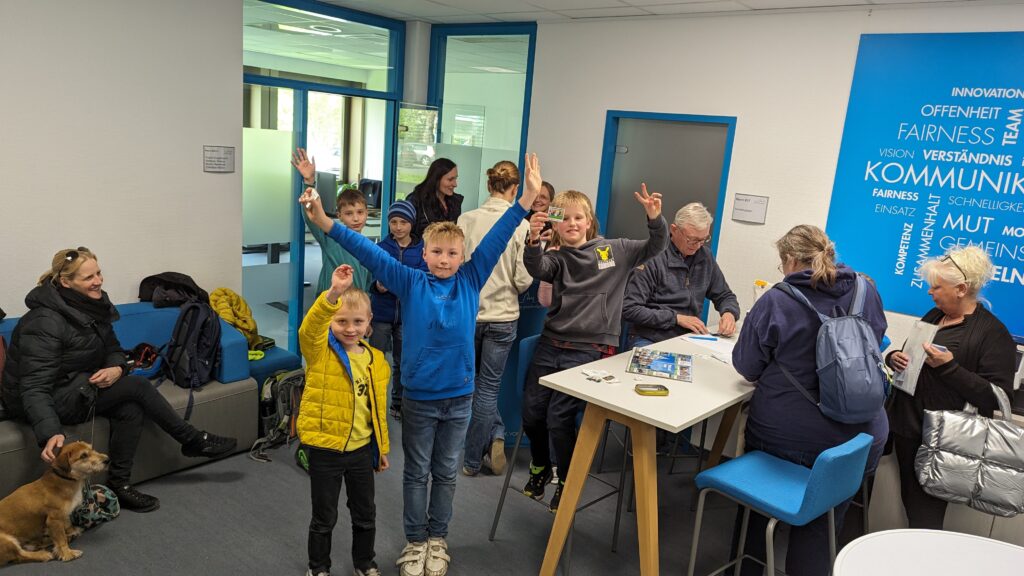 Kinder halten ihre Sticker in die Kamera und lachen glücklich in die Kamera