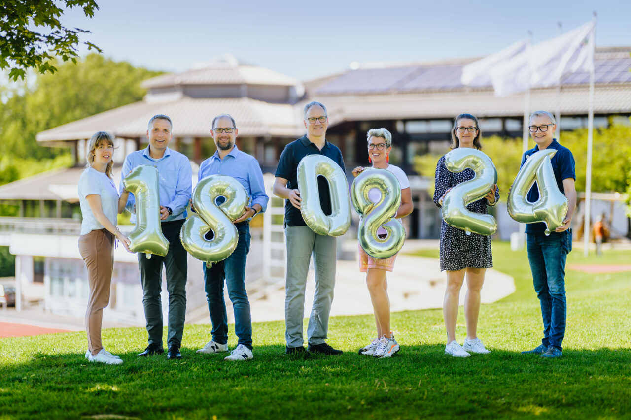Personen die Zahlen Lufballons in der Hand halten mit dem Datum 18 08 24