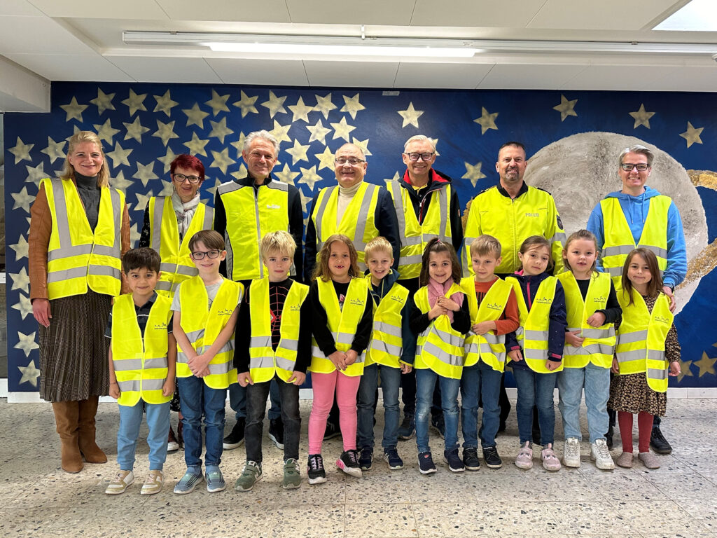 Gruppe von Erwachsenen und Kindern die eine Warnweste tragen