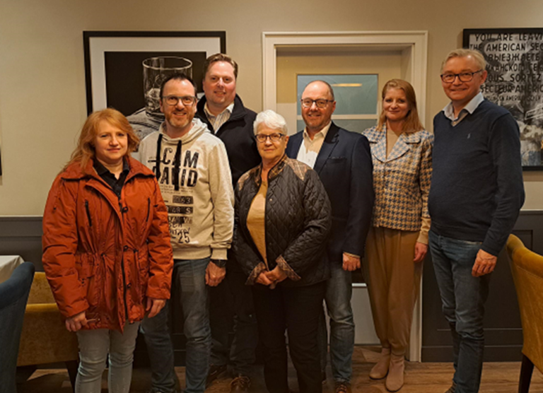 Personen stehen in einer Reihe für ein Gruppenbild