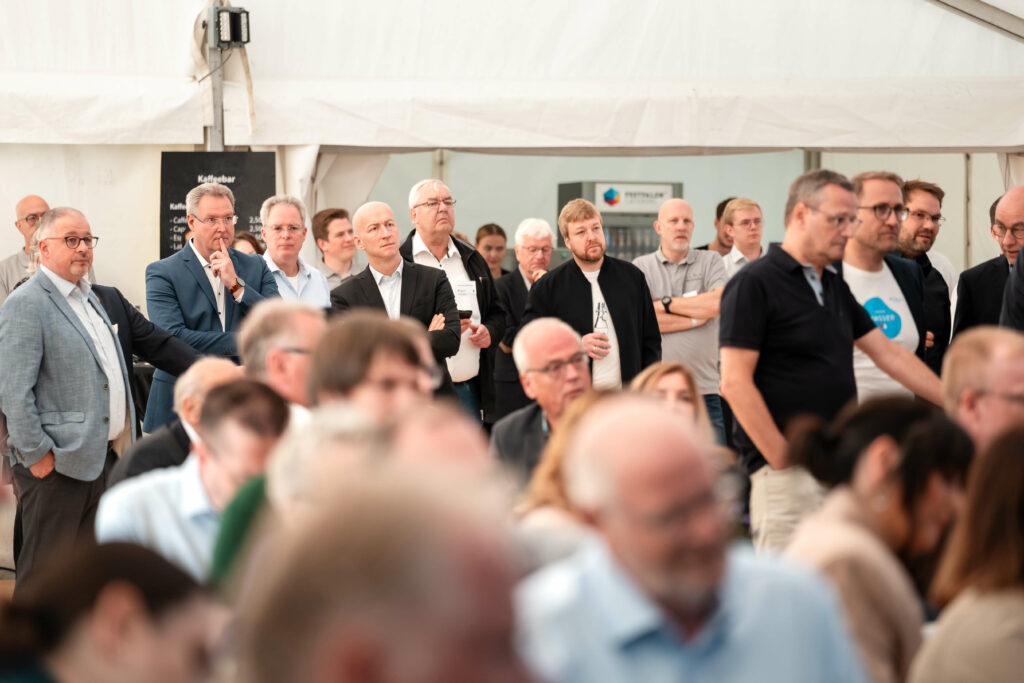 Personengruppe schaut in eine Richtung und hört gespannt zu