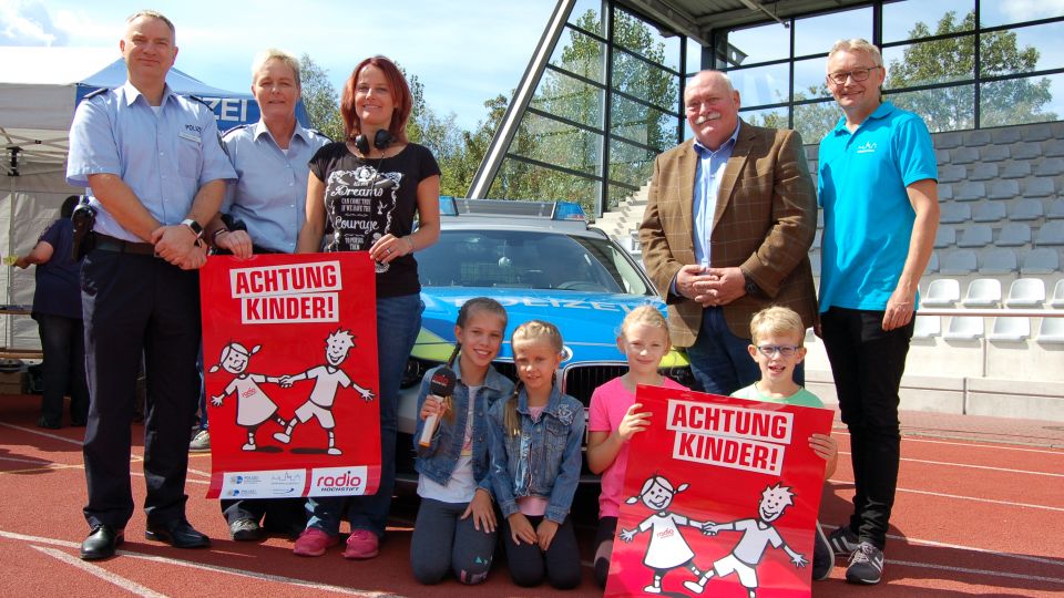 Personen vor einem Polizeiauto im Ahorn Sportpark