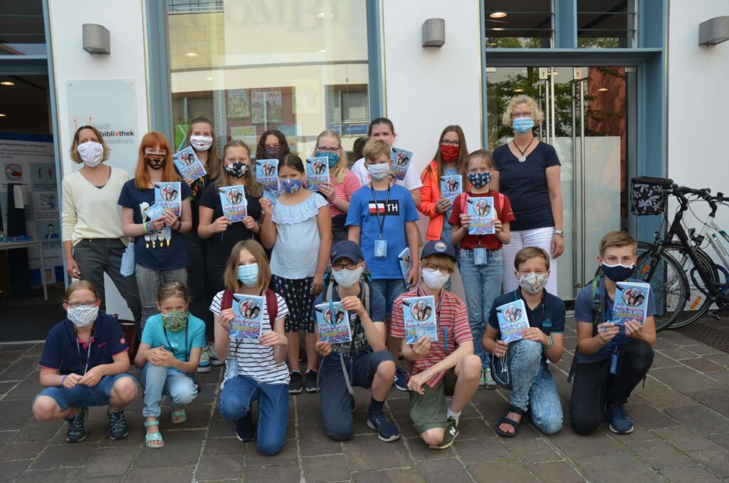 Susanne Kirchner (links), Koodinatorin des Kulturrucksackes, und Erika Berners-Kaffenberger (rechts), Leiterin der Kinderbibliothek, freuen sich gemeinsam mit den Kindern auf den ersten Testlauf des digitalen Rätselratens.