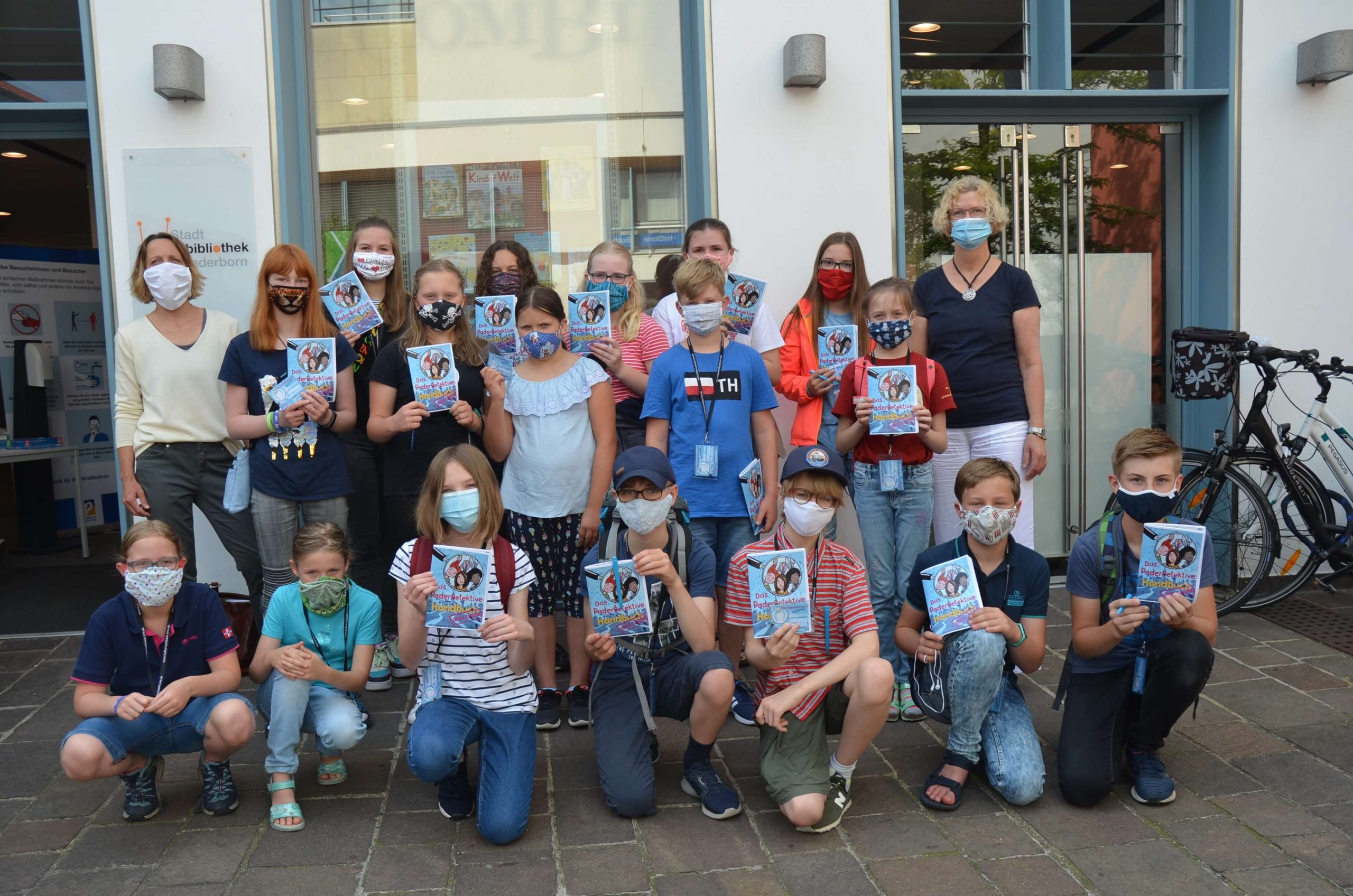 Susanne Kirchner (links), Koodinatorin des Kulturrucksackes, und Erika Berners-Kaffenberger (rechts), Leiterin der Kinderbibliothek, freuen sich gemeinsam mit den Kindern auf den ersten Testlauf des digitalen Rätselratens.
