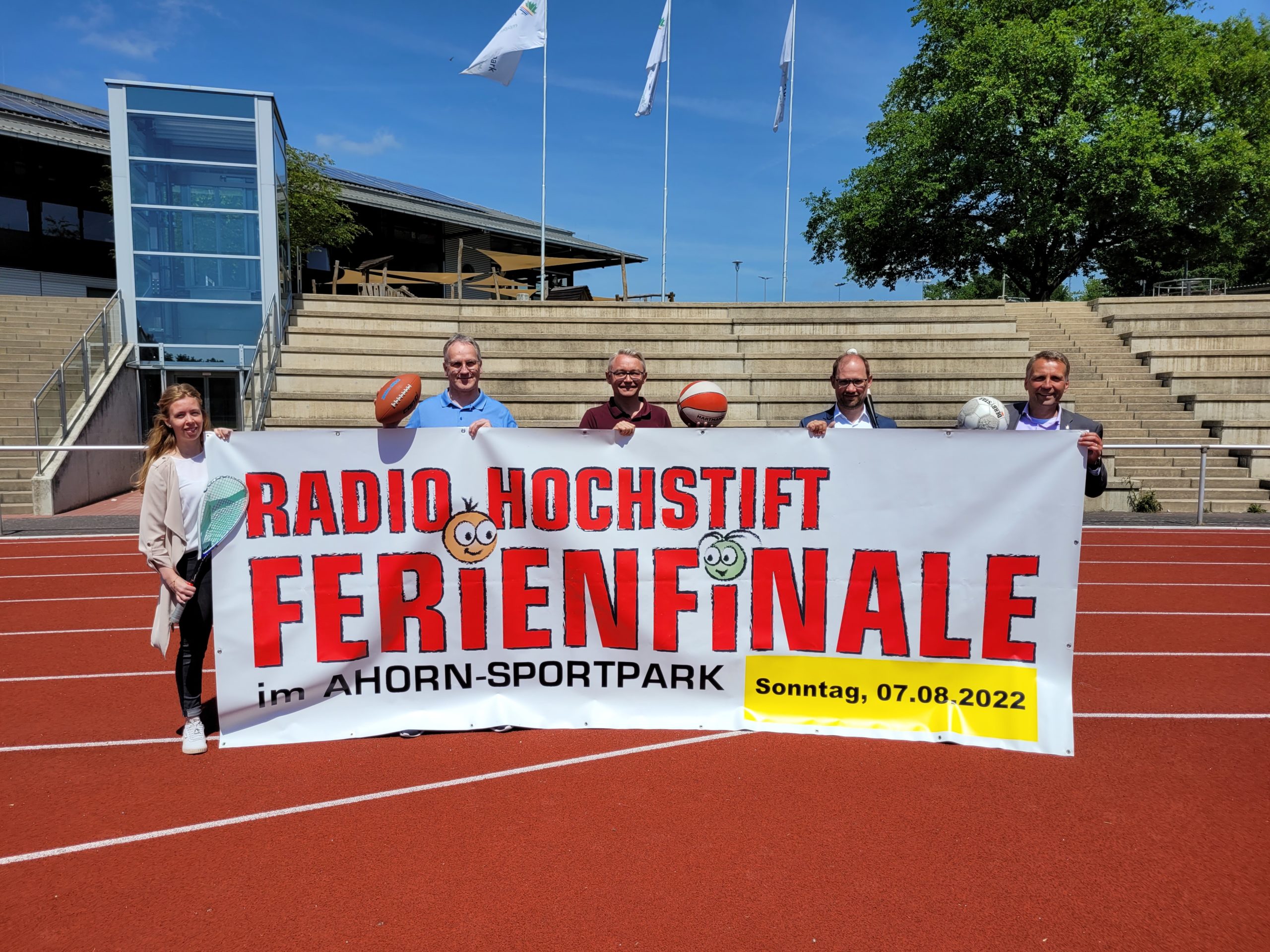 Personen halten einen großen Banner mit dem Schriftzug Radio Hochstift Ferienfinale